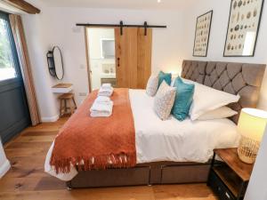 a bedroom with a large bed with towels on it at Carines Barns - Pol in Newquay