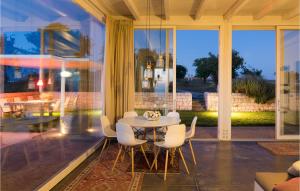 uma sala de jantar com uma mesa e cadeiras brancas em 3 Bedroom Awesome Home In Ragusa em Ragusa