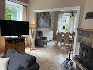 a living room with a television and a dining room at Haasehof in Sittensen