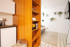 a kitchen with wooden cabinets and a living room at cosy studio#heart of Le Marais.2 in Paris