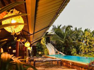 a swimming pool next to a house with a building at Optimum Residencies in Negombo