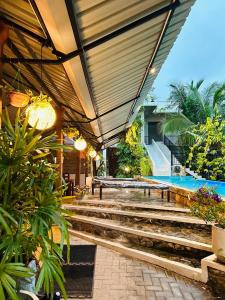 a resort with a swimming pool and a patio with stairs at Optimum Residencies in Negombo