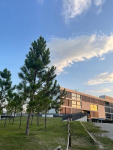 un edificio con árboles frente a un edificio en Departamento Country Puerto del Águila- Lago los Molinos in 