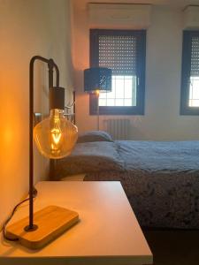 a lamp on a table in a bedroom with a bed at Civico 14 a Bologna in Castel Maggiore