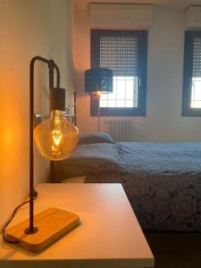 - une lampe sur une table dans une chambre avec un lit dans l'établissement Civico 14 a Bologna, à Castel Maggiore