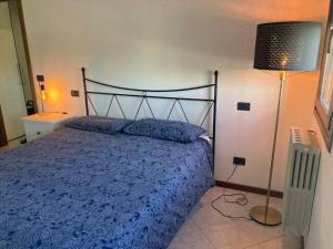 a bedroom with a bed with a blue comforter and a lamp at Civico 14 a Bologna in Castel Maggiore