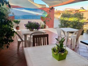 an outdoor patio with tables and chairs and plants at Casa Bea B&B in Tortolì