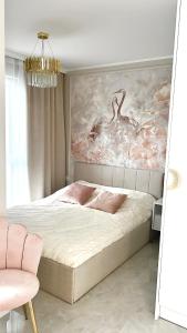 - une chambre avec un lit et une peinture d'oiseaux dans l'établissement LuxApart Apartamenty Jantar, à Jantar