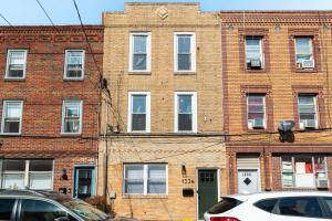 a brick building with a white car parked in front of it at E Passyunk Ave 1 BR Gem - Prime Location! in Philadelphia