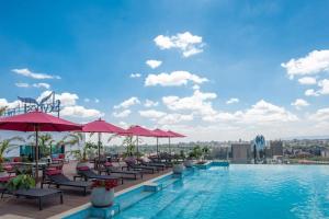 a pool with chairs and umbrellas on top of a building at SkyNest by Merlion - Urban luxury apartment in Nairobi