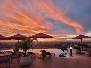 a patio with chairs and umbrellas at sunset at SkyNest by Merlion - Urban luxury apartment in Nairobi