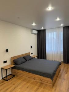 een slaapkamer met een groot bed en een raam bij Люкс Апартаменты White Pearl на Подолье in Vinnytsya