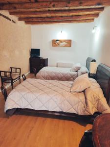 a bedroom with two beds and a wooden floor at Casa Rural Casona Camino Pedraza - 4 Estrellas in Arcones