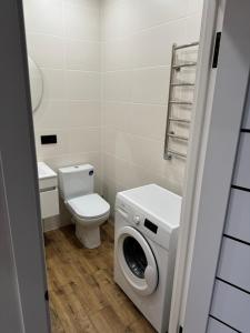 La salle de bains est pourvue d'un lave-linge et de toilettes. dans l'établissement Люкс Апартаменты White Pearl на Подолье, à Vinnytsia