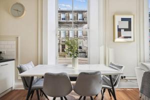 a dining room with a table and chairs and a window at (G1) Elegant 2 bed Blythswood Apartment in Glasgow