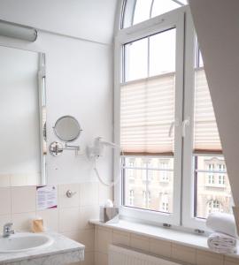 uma casa de banho com um lavatório e uma janela em Focus Hotel Szczecin em Szczecin