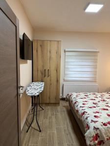 a bedroom with a bed and a table and a window at Apartman Pogled Arilje in Arilje