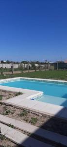 una piscina con acqua blu e un marciapiede di Habitación en hermosa casa de descanso a Laguna Brava