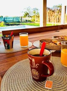 a cup of coffee sitting on a table with orange juice at Habitación en hermosa casa de descanso in Laguna Brava