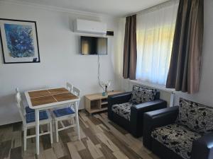 a living room with a couch and a table and chairs at Németh Apartmanok in Zalakaros
