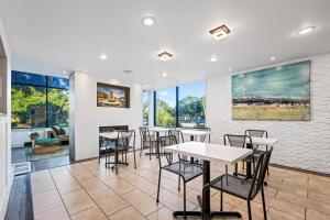 un comedor con mesas, sillas y ventanas en Charleston Creekside Inn, en Charleston