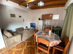 kuchnia i salon ze stołem i kanapą w obiekcie Leosan departamento w mieście Puerto Iguazú
