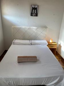 a bedroom with a white bed with a white headboard at Leosan departamento in Puerto Iguazú