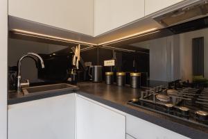 a kitchen with a sink and a stove top oven at Golden Apartments Warsaw - Top Location - Krakowskie in Warsaw