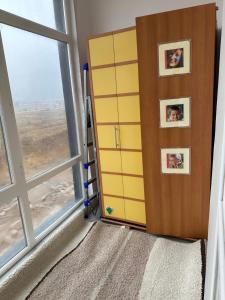 um quarto com um armário amarelo e uma janela em однокомнатная квартира em Prigorodnyy