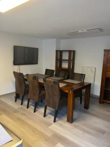 a dining room table with chairs and a flat screen tv at Helle Wohnung Zentrumslage,50m2 in Bayreuth