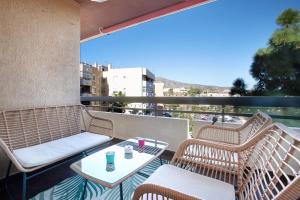 a balcony with two wicker chairs and a table at Apartamento Armonia in Torremolinos
