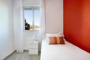 a bedroom with a white bed and a window at Apartamento Armonia in Torremolinos