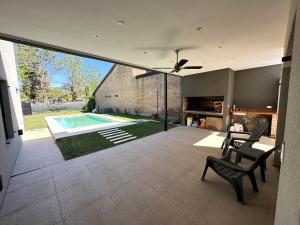 sala de estar con piscina y ventilador de techo en Casa con piscina en Roldán en Roldán