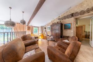 a living room with leather furniture and a balcony at Mas Titourin - Moulin du 18ème entièrement rénové in Ansouis