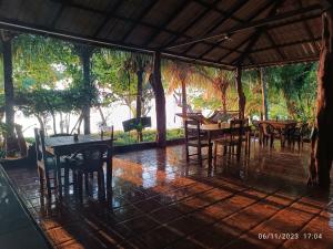 an outdoor dining area with tables and chairs at Hostel La Gloria in Ometepe
