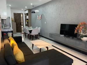 a living room with a couch and a tv and a table at Panaroma Apartment Đà Lạt in Da Lat