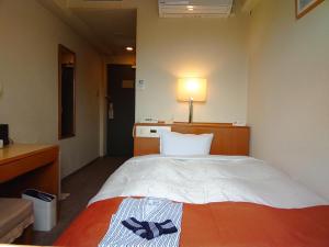 Una habitación de hotel con una cama con luz. en Aomori Green Park Hotel Annex en Aomori