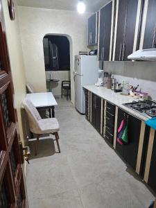 a kitchen with a table and a white refrigerator at RUSO'S APARTMENT in Kobuleti