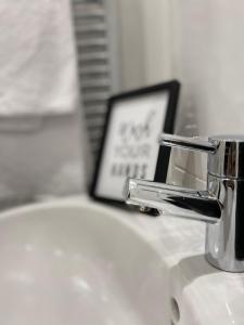 - un lavabo avec un robinet en chrome et une photo dans l'établissement Leicester City Centre Apartment with Parking, à Leicester