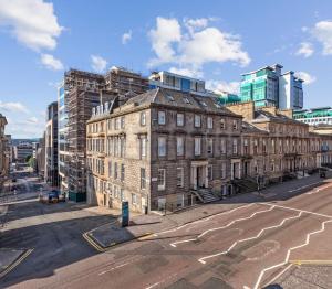 an old brick building on a city street with tall buildings at (G2) Central 1 Bed Blythswood Flat in Glasgow