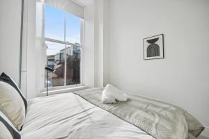 a white bedroom with a bed and a window at (G2) Central 1 Bed Blythswood Flat in Glasgow