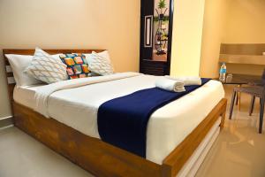 a bedroom with a large bed with blue and white sheets at LOYAL RESIDENCY in Sultan Bathery
