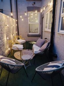 a patio with chairs and a table and lights at Stylish 3BR house near Liverpool Football Club in Liverpool