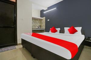 um quarto com uma cama grande e almofadas vermelhas em OYO Hotel Dreamland Residency em Nova Deli