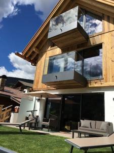 a house with a balcony with chairs and windows at Mountain Chalet Ghilga in Ortisei