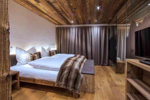 a bedroom with a large bed with a wooden ceiling at Mountain Chalet Ghilga in Ortisei