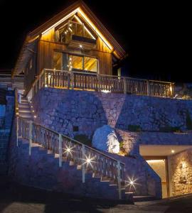 a house with stairs leading up to a building with lights at Mountain Chalet Ghilga in Ortisei