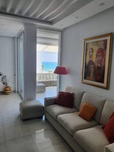 a living room with a couch and a painting on the wall at bel appartement vue sur mer in Nabeul