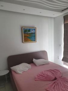a bedroom with a pink bed with two pillows at bel appartement vue sur mer in Nabeul