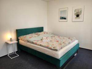 a bedroom with a bed with a green headboard at Baterky in Prague